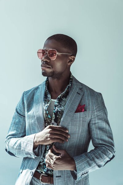 Африканский американец в модном костюме позирует
