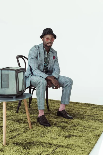 Hombre con estilo en gafas de sol y traje en silla — Foto de stock gratis