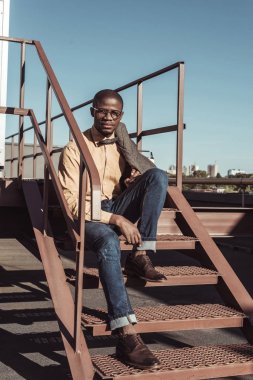 merdivenlerde oturan şık adam
