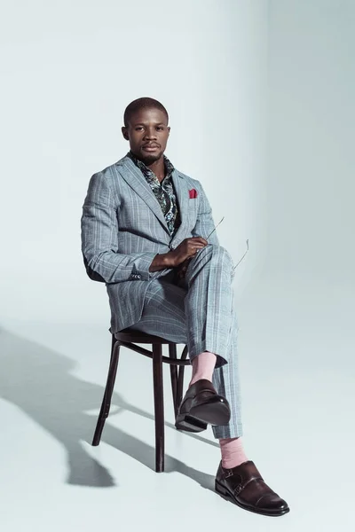 Афроамериканський чоловік у костюмі на стільці — стокове фото