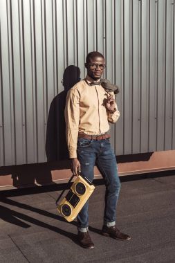 Afrika kökenli Amerikalı adam tutarak Boombox ve ceket