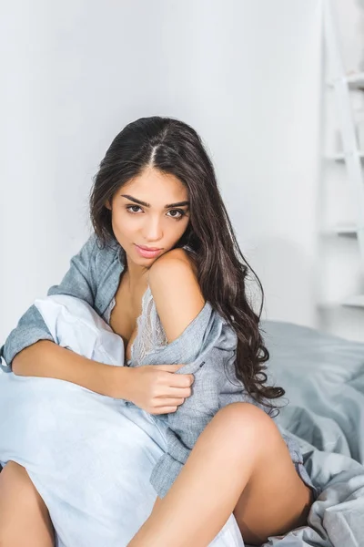 Sexy žena, sedící na posteli — Stock fotografie