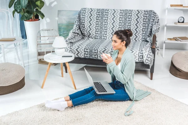 Mujer joven con portátil en casa — Foto de Stock