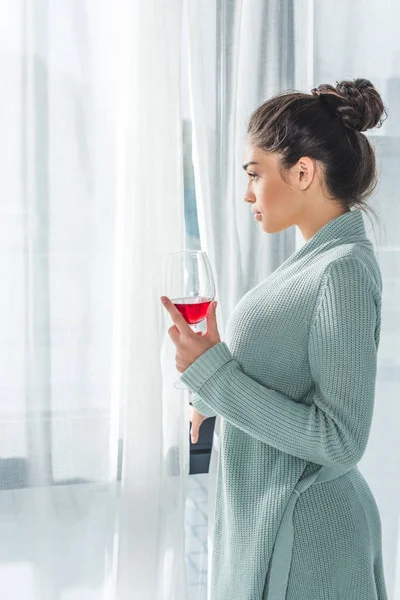 Mujer joven bebiendo vino en casa — Foto de Stock