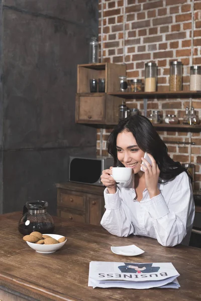 Woman talking by phone and drinking coffee — Stock Photo, Image