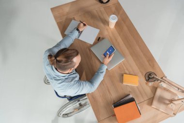 adam akıllı telefon kullanarak tekerlekli sandalye üzerinde