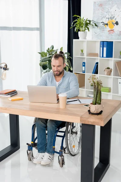 Homme d'affaires en fauteuil roulant travaillant avec un ordinateur portable — Photo