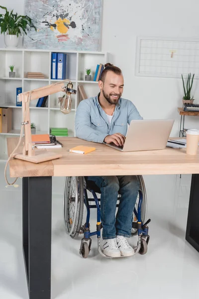 Businessman on wheelchair working with laptop — Free Stock Photo