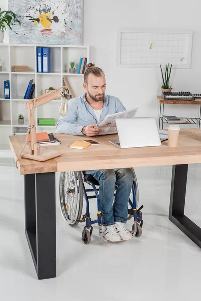 Disabled man reading newspaper — Free Stock Photo