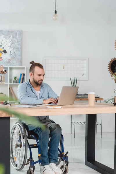 Mann im Rollstuhl arbeitet mit Laptop — Stockfoto
