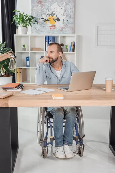 Disabled man sitting at workplace — Free Stock Photo