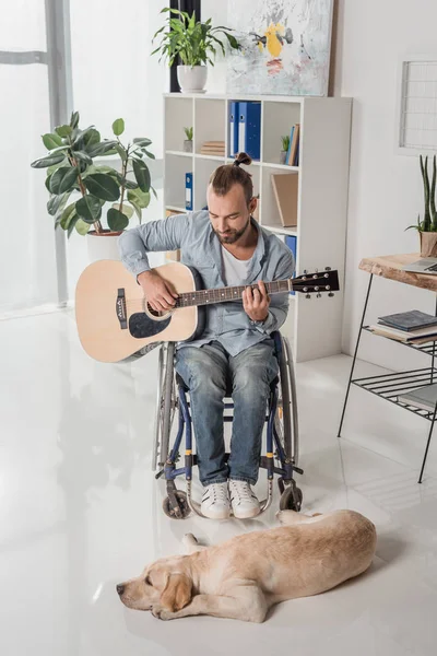 Man on wheelchair playing guitar — Stock Photo, Image