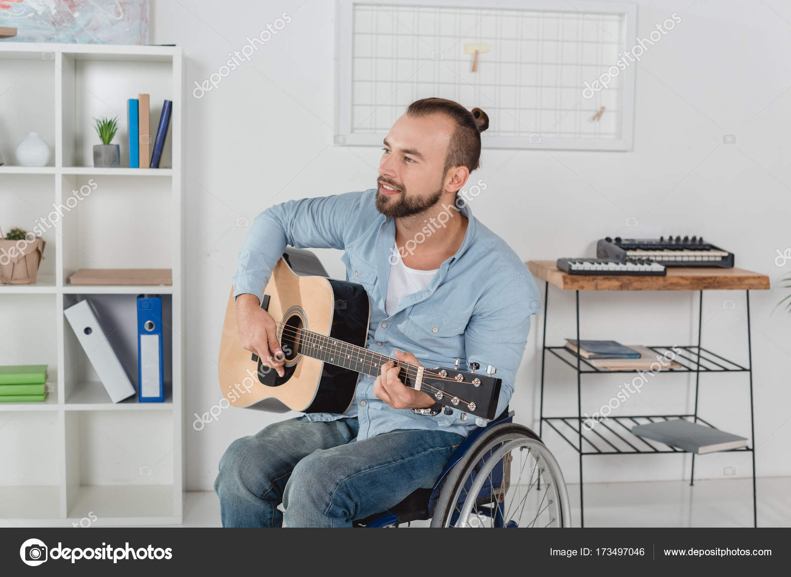 Man on wheelchair playing guitar Stock Photo by ©IgorVetushko 173497046