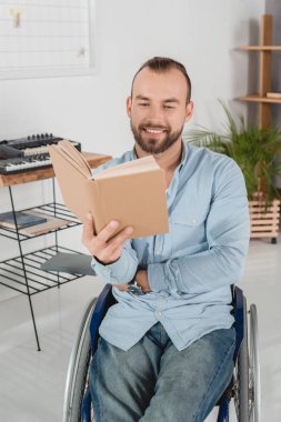 Adam tekerlekli sandalye kitap okuma