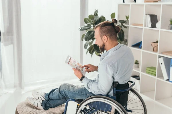 Człowiek na wózku przy pomocy tabletu — Zdjęcie stockowe