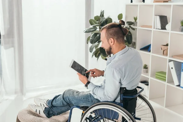 Człowiek na wózku przy pomocy tabletu — Zdjęcie stockowe