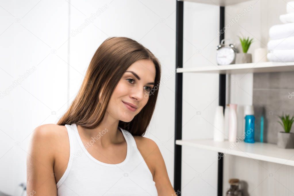 Happy woman standing in bathroom 