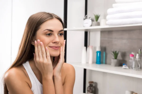 Niña aplicando crema en la cara — Foto de Stock