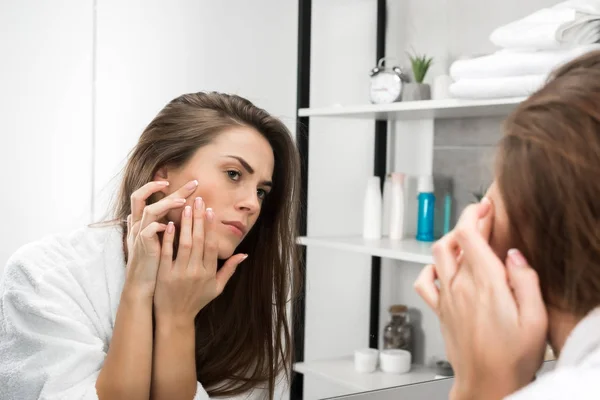 Mulher verificando a pele do rosto — Fotografia de Stock