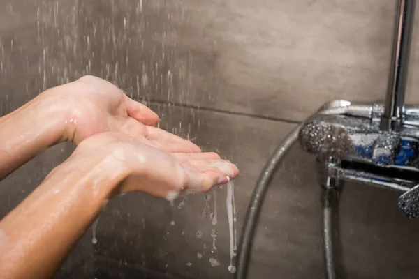 Gotas de agua cayendo sobre las manos femeninas — Foto de Stock