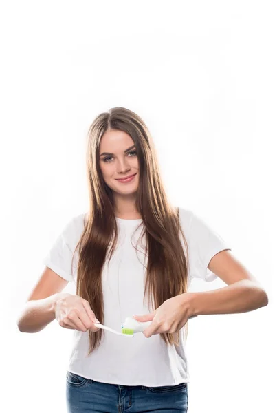 Menina apertando pasta de dentes na escova — Fotografia de Stock Grátis