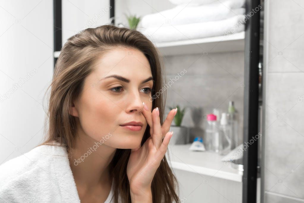Girl checking face skin