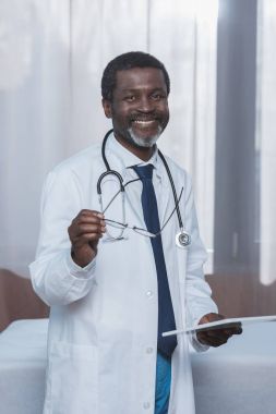 Doktor holding gözlük ve tablet