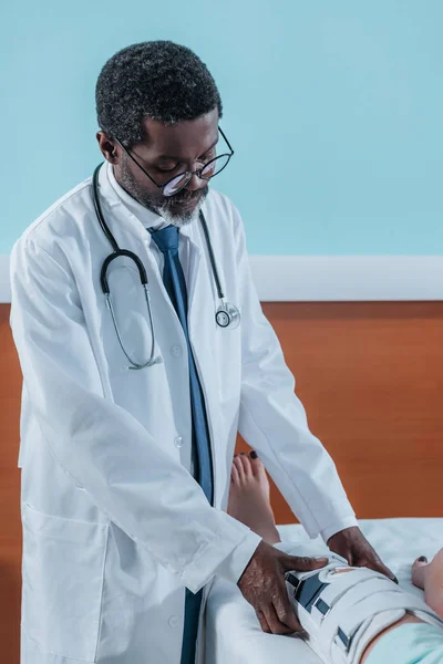 Médico colocando em cinta de perna — Fotografia de Stock Grátis