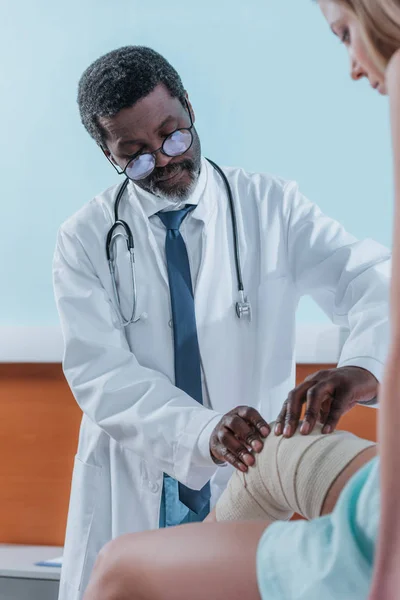 Médico poniéndose un vendaje elástico — Foto de Stock