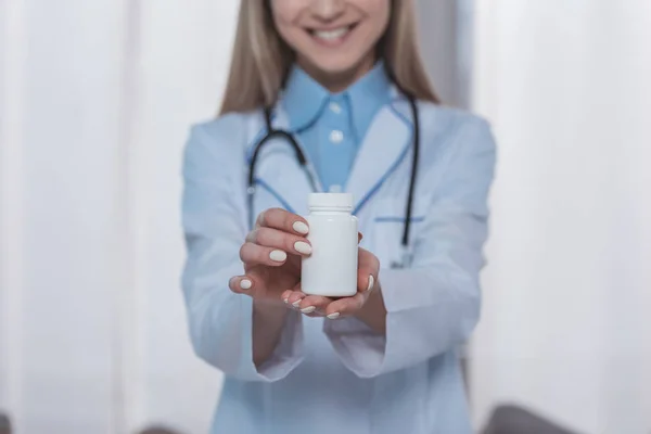 Médecin montrant pot en plastique de pilules — Photo