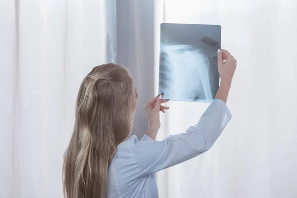 Врач смотрит на рентген пациента — стоковое фото