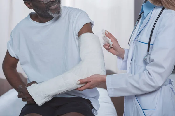 Lekarz, bandażowanie ręki pacjenta — Zdjęcie stockowe
