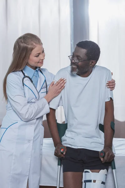 Doctor ayudando al paciente a ponerse de pie — Foto de Stock