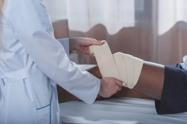 Médico poniéndose un vendaje elástico — Foto de Stock