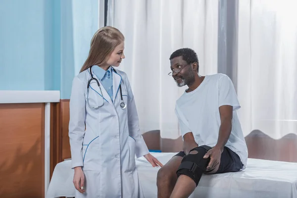Patient zeigt Knie mit Korsett — Stockfoto