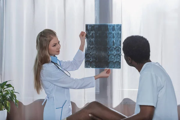 Arzt zeigt Patient Röntgenbild — Stockfoto