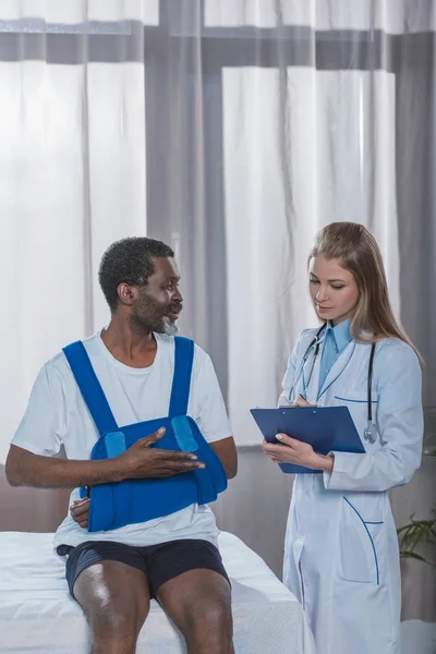 Médecin et patient avec attelle de bras — Photo