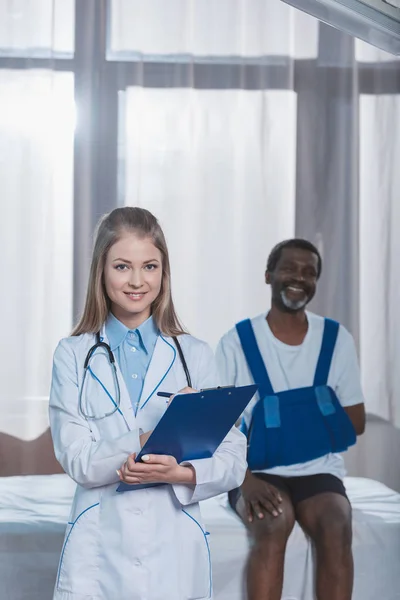 Doctor and patient with arm brace — Stock Photo, Image