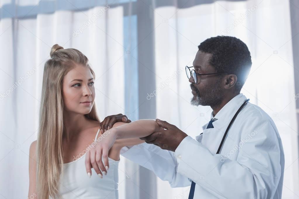 Doctor examining patient elbow