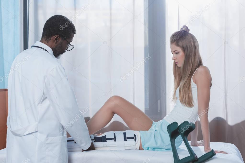 doctor putting on leg brace