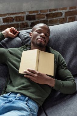 african american man sleeping on sofa clipart