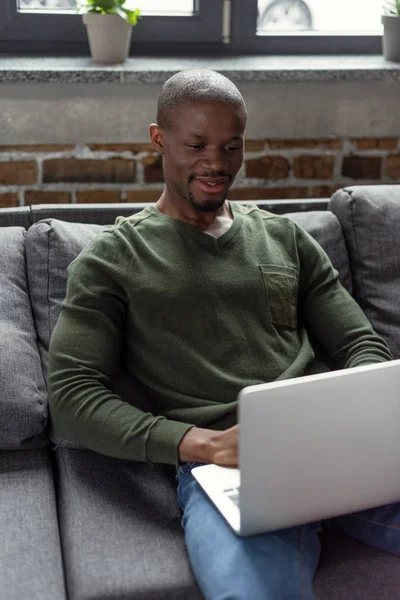 Afroamerikansk man skriver på laptop — Stockfoto