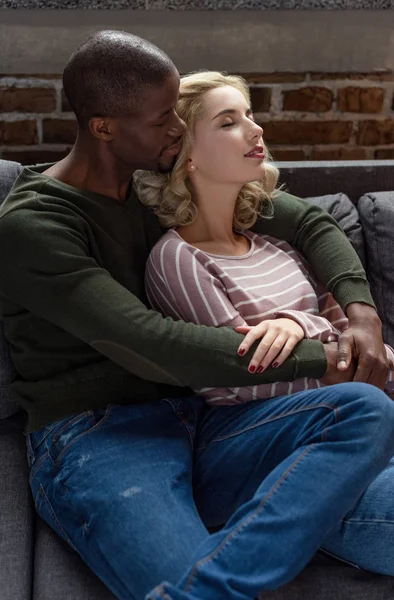 Retrato Homem Americano Africano Sensual Abraçando Namorada Enquanto Descansando Sofá — Fotografia de Stock
