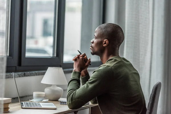 Tankeväckande afroamerikanska man arbetar hemma — Stockfoto