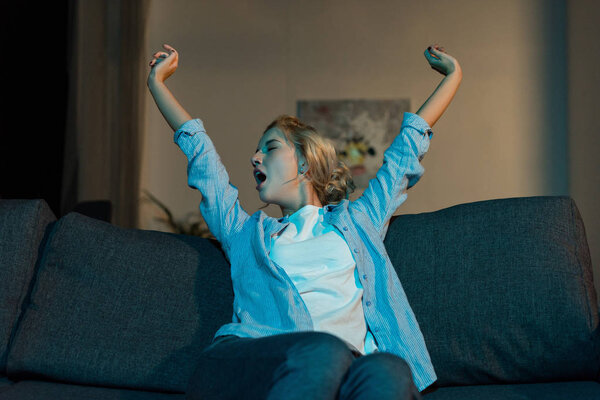 yawning woman sitting on sofa