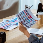 Vue partielle du photographe regardant des échantillons de photoshoot sur le lieu de travail au bureau