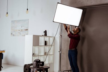 african american photographer getting ready for photoshoot in studio clipart