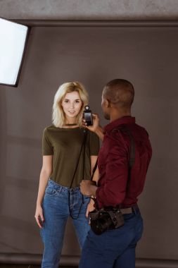african american photographer and caucasian model having photoshoot in studio clipart