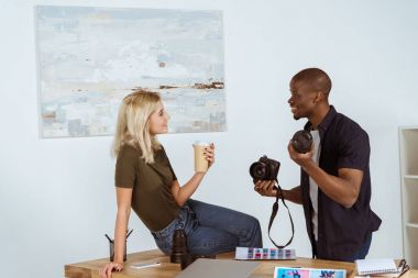 ofiste işyerinde konuşmayı Interracial fotoğrafçılar yan görünüm