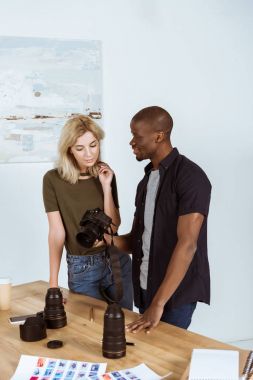 Interracial fotoğrafçılar fotoğraf makinesi Studio işyerinde söz